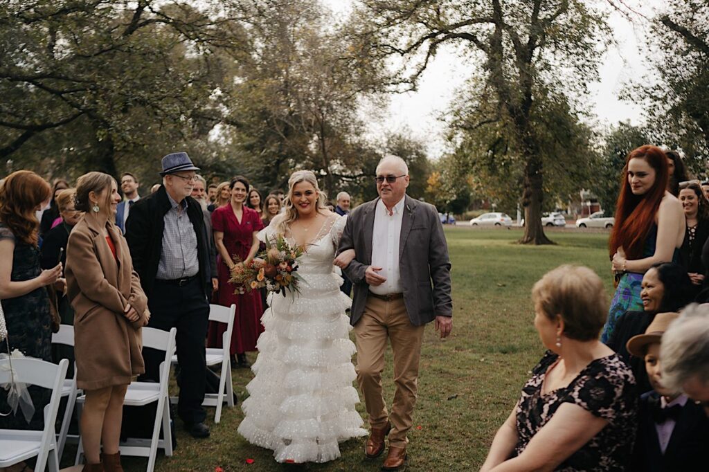 023_bride walking down aisle at circle of trees Edinburgh Gardens Fitzroy