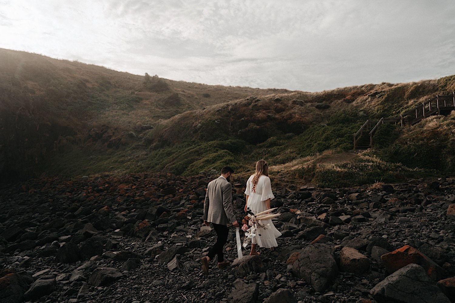 57_Flinders Elopement Mornington Peninsula Wedding couple walking on the rocks along Flinders Cliff after their Elopement