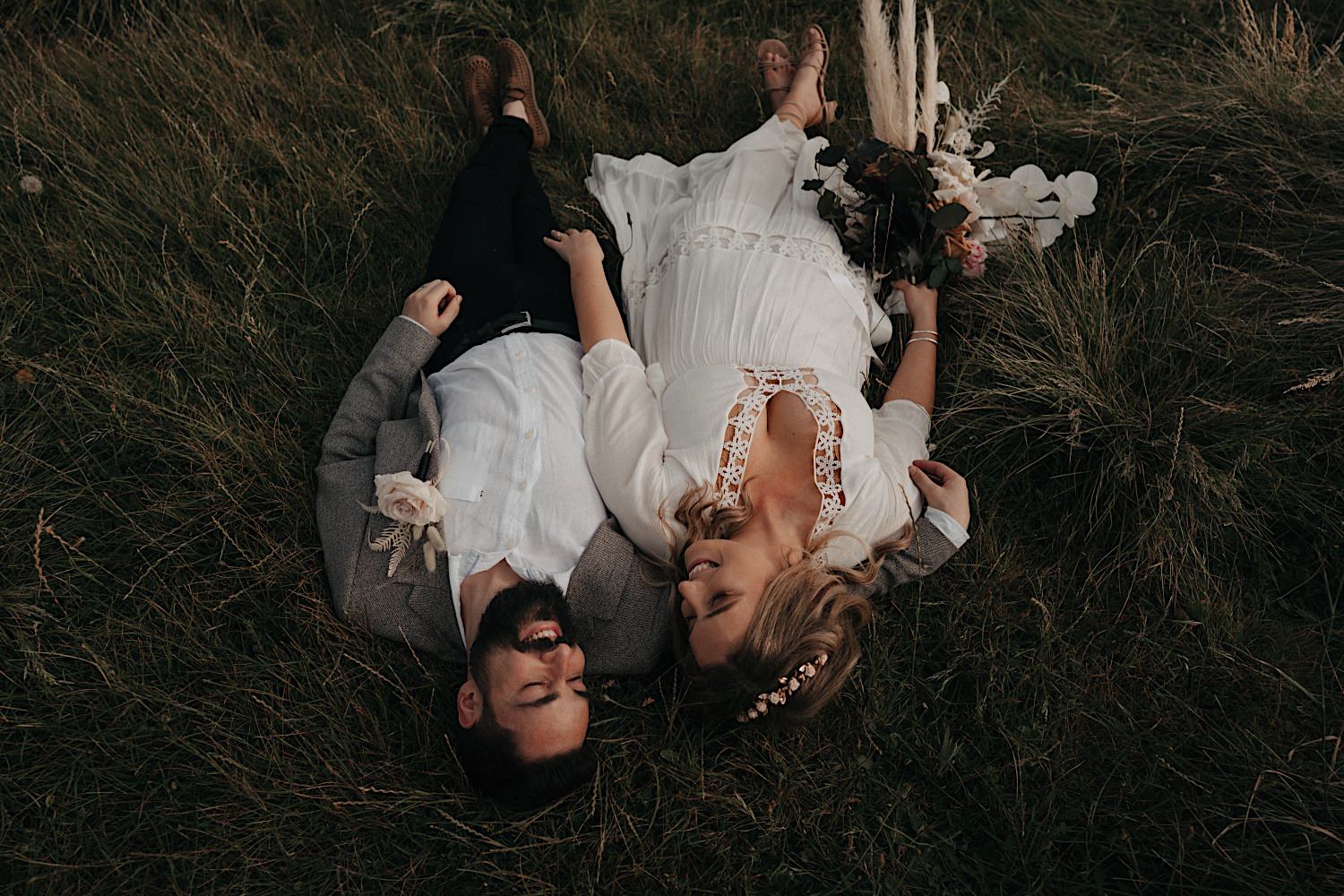 68_Flinders Elopement Mornington Peninsula Wedding couple laying down in the long grass after their flinders wedding ceremony