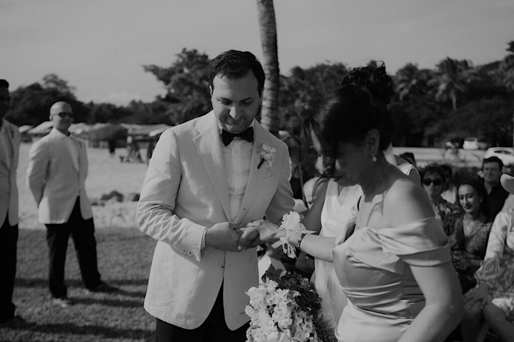 090_fiji-wedding-couple-holding-hands Black and white image of the bride’s mother handing her over to the groom, during their wedding ceremony in Fiji