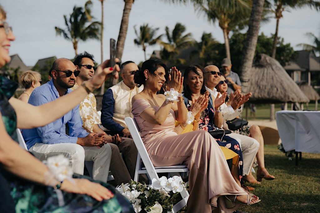 099_guests-at-natadola-bay-wedding-fiji Guests clapping and celebrating during a wedding ceremony at Natadola Bay, Fiji