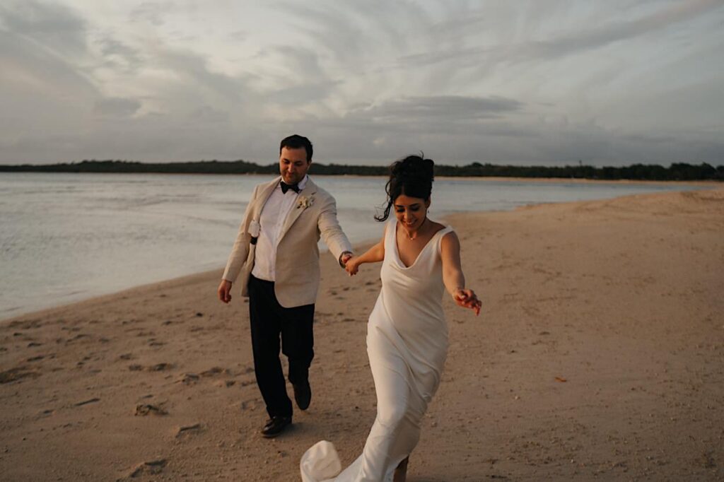 213_couple-portraits-after-ceremony-fiji-wedding Wedding couple running playfully along the beach after their ceremony at the Intercontinental Resort in Fiji, surrounded by a stunning tropical backdrop