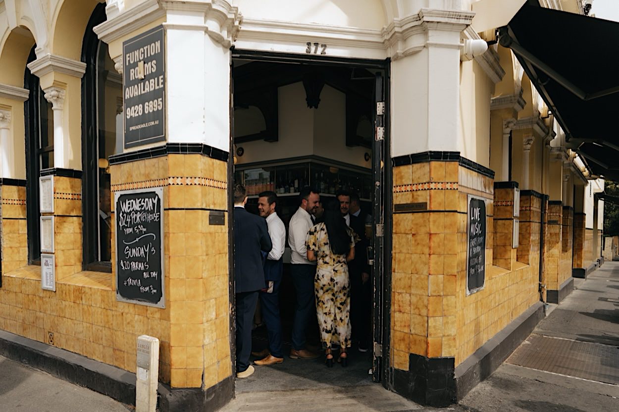 050_guests-spread-eagle-glasshaus-brucke-wedding-melbourne Guests enjoying beers outside the Spread Eagle Pub in Richmond, Melbourne, before heading to the ceremony at the Glasshaus Brucke wedding