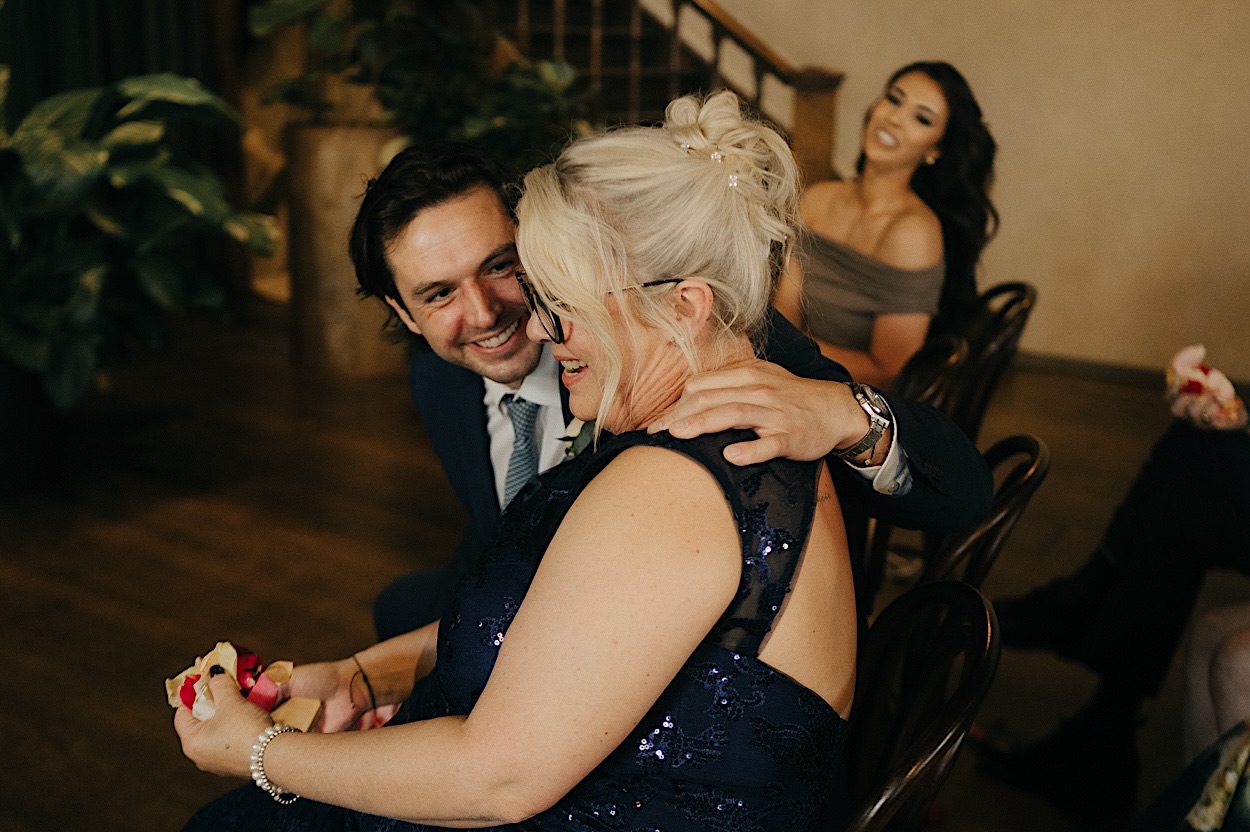 096_guests-ceremony-richmond-melbourne Mother of the groom and groomsman laughing together during the ceremony at a wedding in Richmond, Melbourne