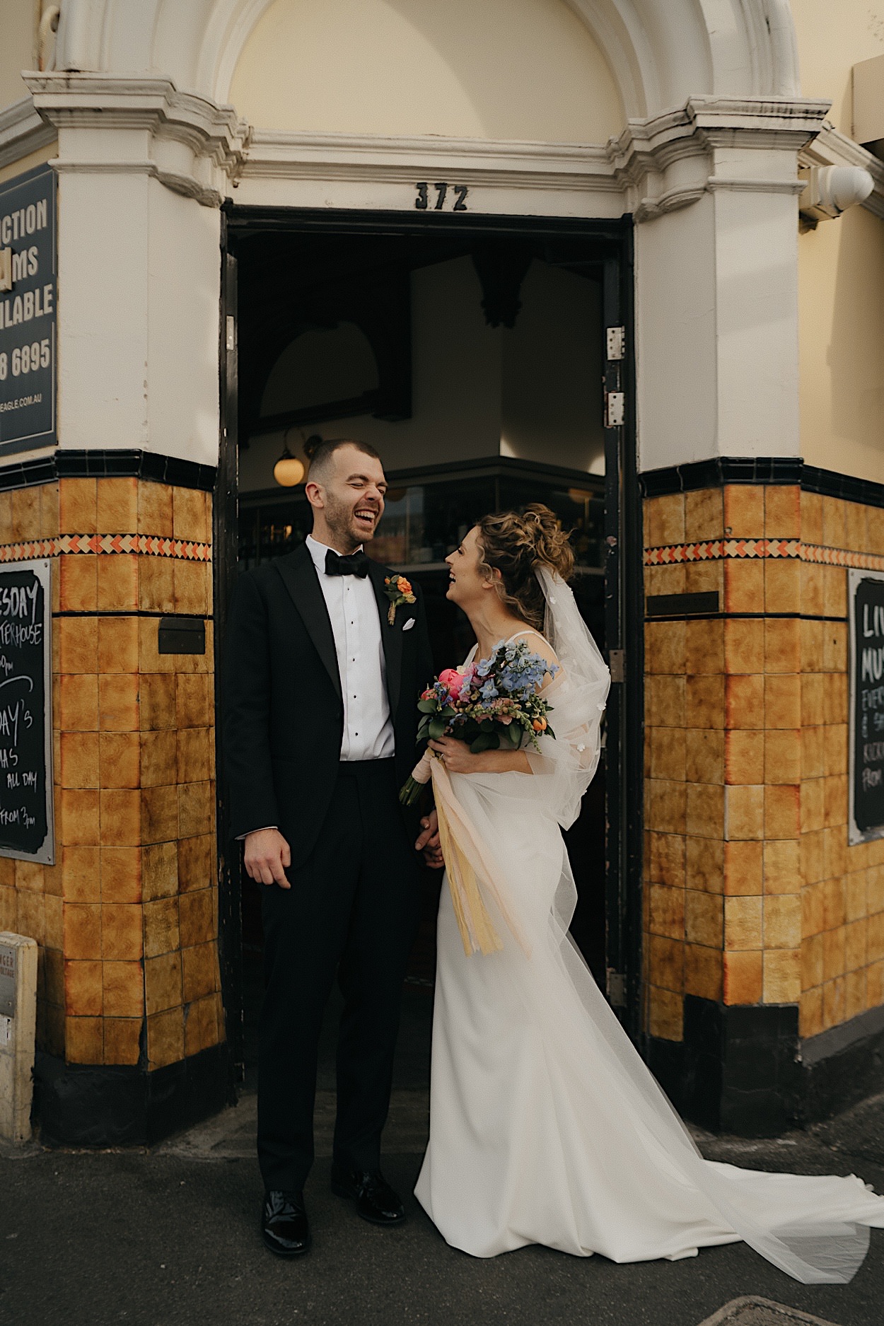 133_couple-portraits-spread-eagle-glasshaus-wedding-melbourne Couple posing outside The Spread Eagle pub in Melbourne, where they had their first date, during their wedding portraits