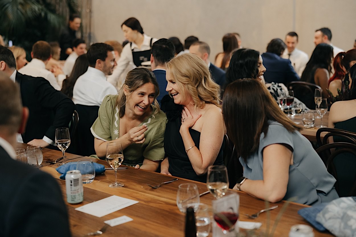 161_guests-laughing-glasshaus-brucke-reception-melbourne-richmond Guests laughing at their table during a reception at Glasshaus Brucke in Richmond, Melbourne