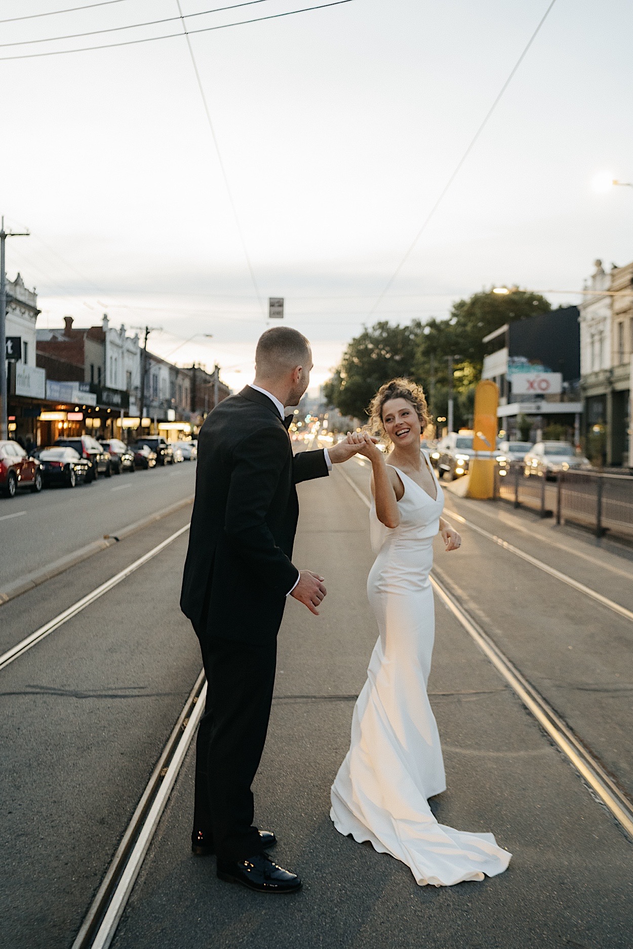 175_couple-portraits-glasshaus-brucke-wedding-melbourne Bride and groom having fun on tram tracks during their couple portraits at a wedding at Glasshaus Brucke in Melbourne