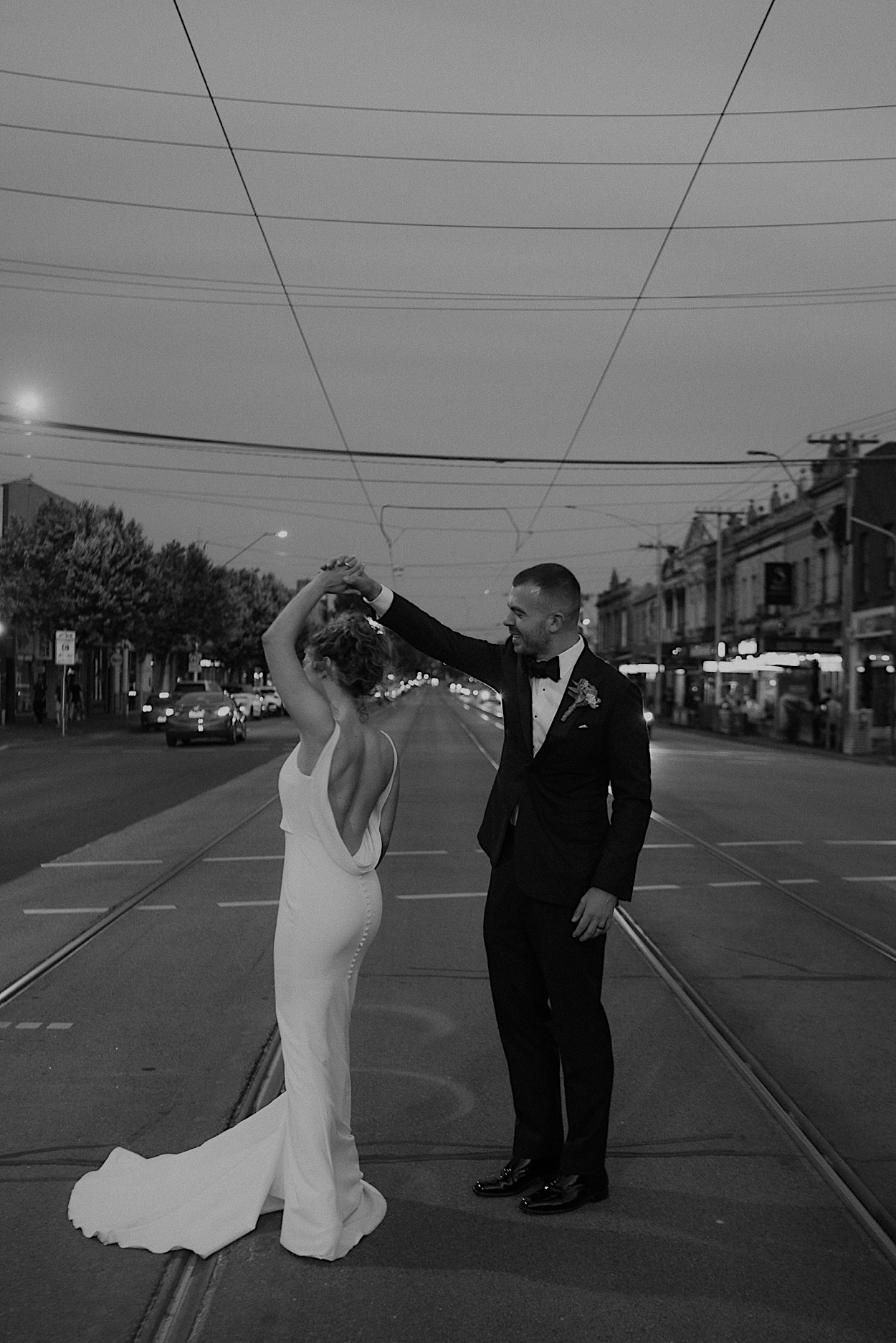 176_glasshaus-brucke-wedding-portraits-by-melbourne-wedding-photographer Bride and groom posing on tram tracks in Richmond for their wedding portraits, captured in black and white by a Melbourne wedding photographer