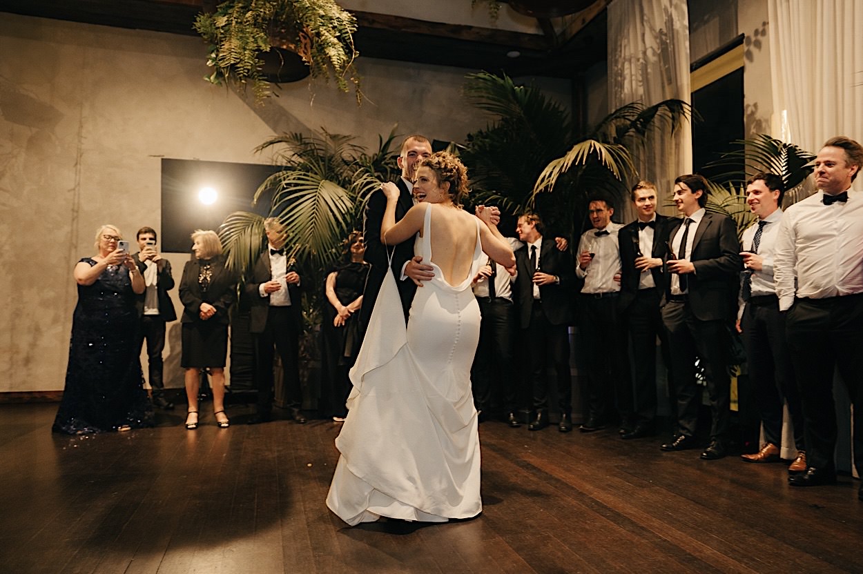 189_couple-dance-glasshaus-brucke-melbourne-wedding Bride and groom dancing at their wedding reception at Glasshaus Brucke in Melbourne, with guests in the background