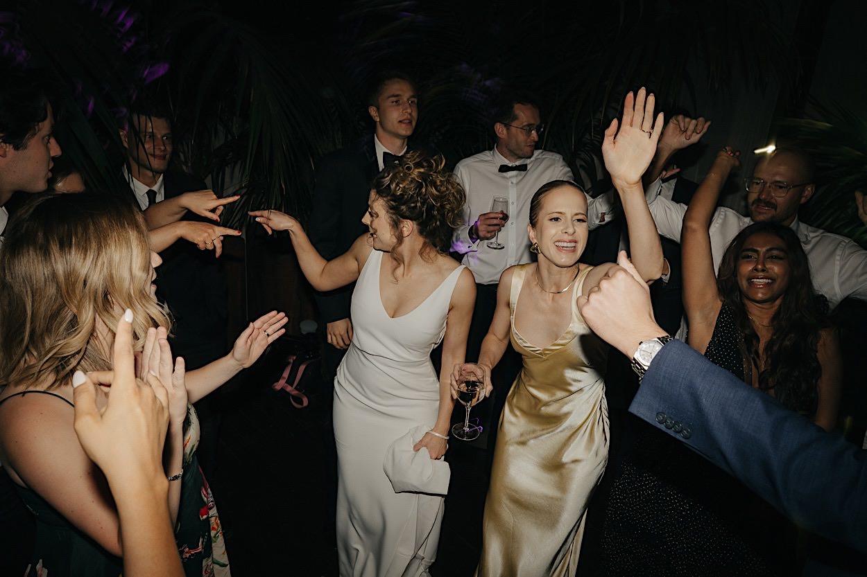 199_guests-dancing-glasshaus-brucke-reception-melbourne-wedding Guests dancing with their hands in the air during a wedding reception at Glasshaus Brucke in Melbourne