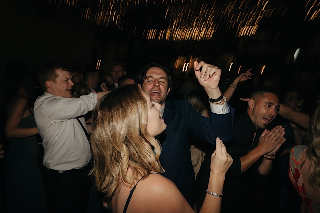201_guests-dancefloor-glasshaus-brucke-wedding-reception Guests dancing on the dancefloor during a wedding reception at Glasshaus Brucke