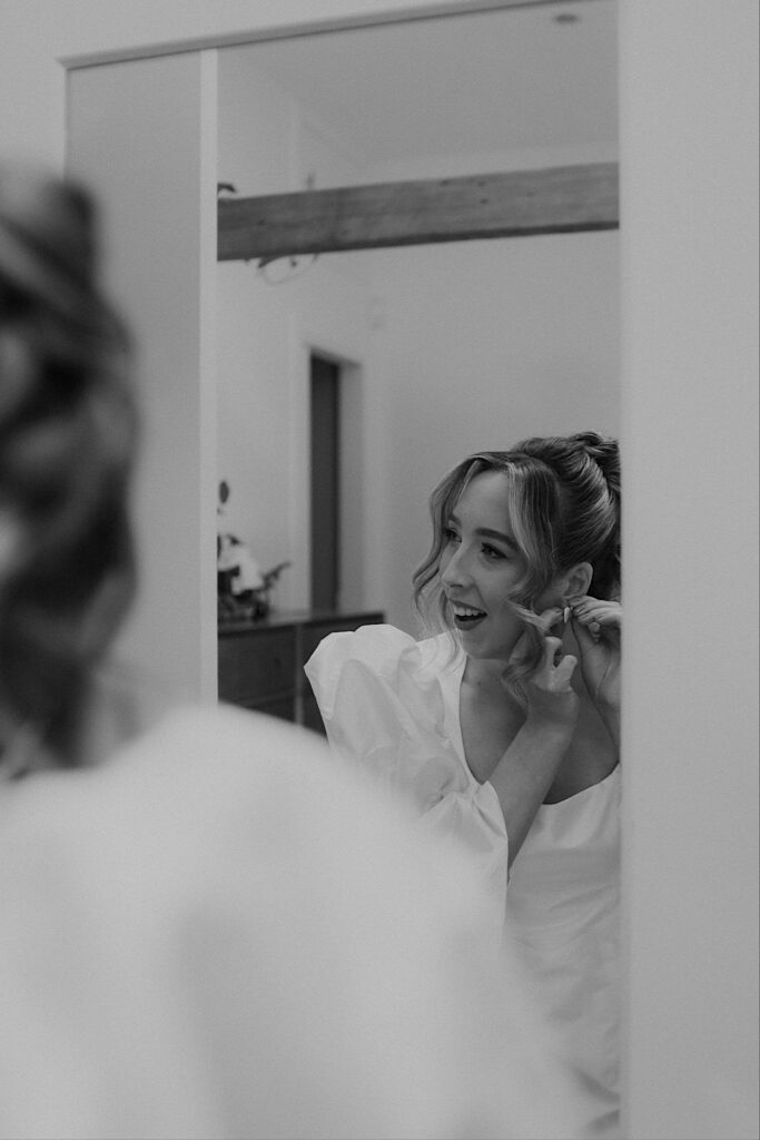 031_bride-preps-before-altar-electric-elopement-melbourne Black and white close-up of the bride putting in her earrings during preparations before her elopement at Altar Electric, Collingwood, Melbourne