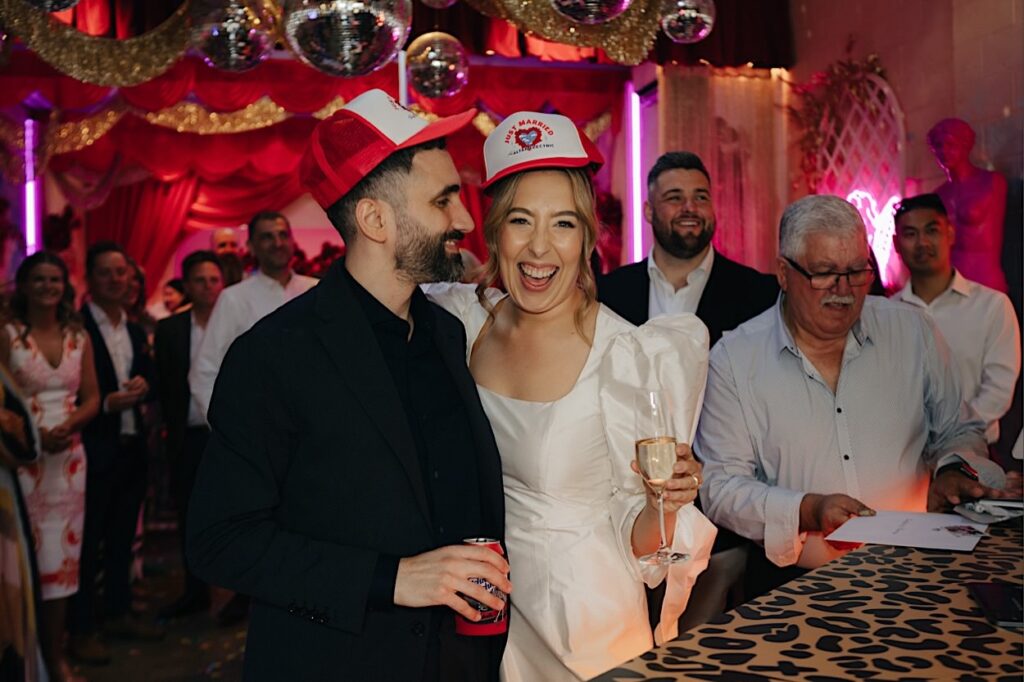 114_couple-with-hats-altar-electric-wedding-collingwood-melbourne Bride and groom laughing while wearing hats at Altar Electric wedding in Collingwood, Melbourne