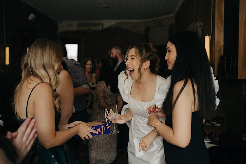 144_guests-mingling-maggie-snacks-and-liquor-wedding-brunswick-east Bride laughing while mingling with guests at Maggie’s Snacks and Liquor wedding reception in Brunswick East