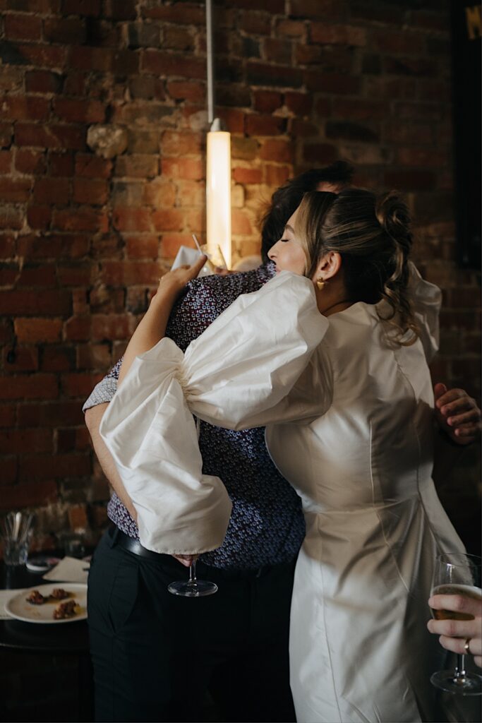 173_bride-hugging-brother-speeches-maggies-snacks-and-liquor-wedding-reception Bride hugging her brother during speeches at the wedding reception at Maggie’s Snacks and Liquor, Brunswick East, Melbourne