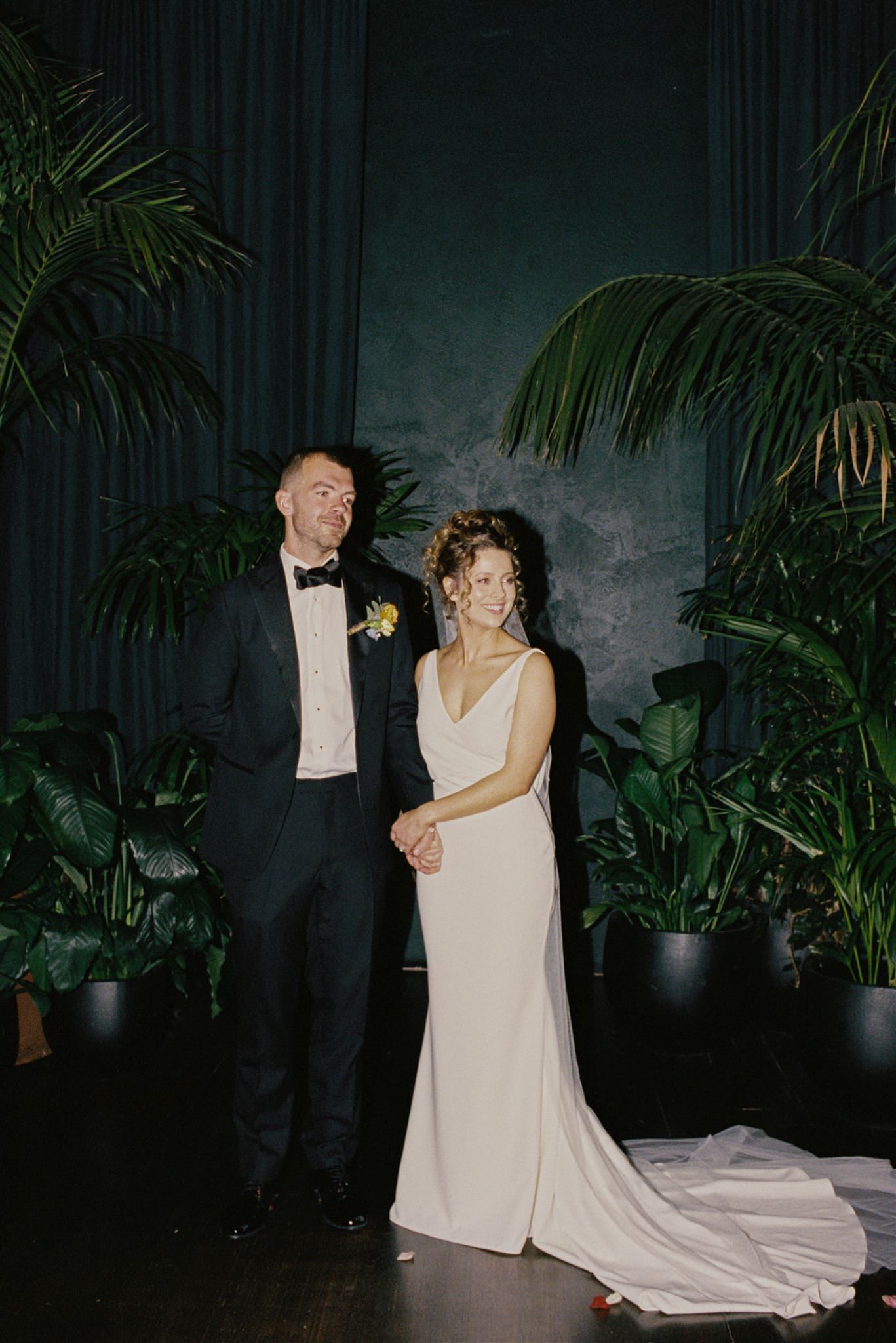 35mm-film-glasshaus-brucke-wedding-ceremony.jpg 35mm film photo of the wedding ceremony at Glasshaus Brücke, featuring a lush greenery backdrop and elegant black drapery