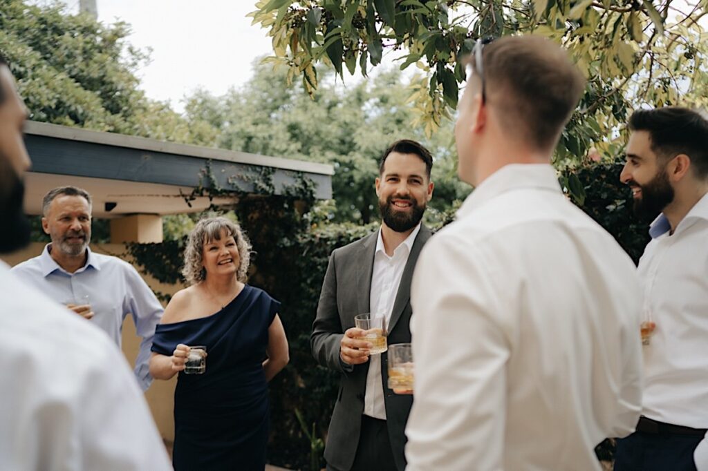 Groom laughing and celebrating with his parents before the wedding at Glasshaus Inside, Cremorne