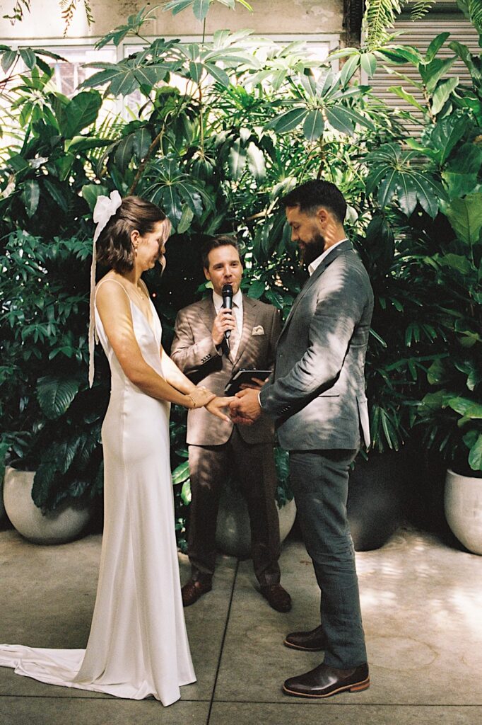 Couple standing in front of lush greenery during their Glasshaus Inside wedding ceremony in Cremorne — shot on 35mm film