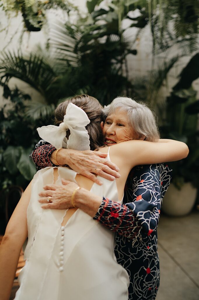 The bride shares a heartfelt hug with her grandmother during their Glasshaus Inside wedding.