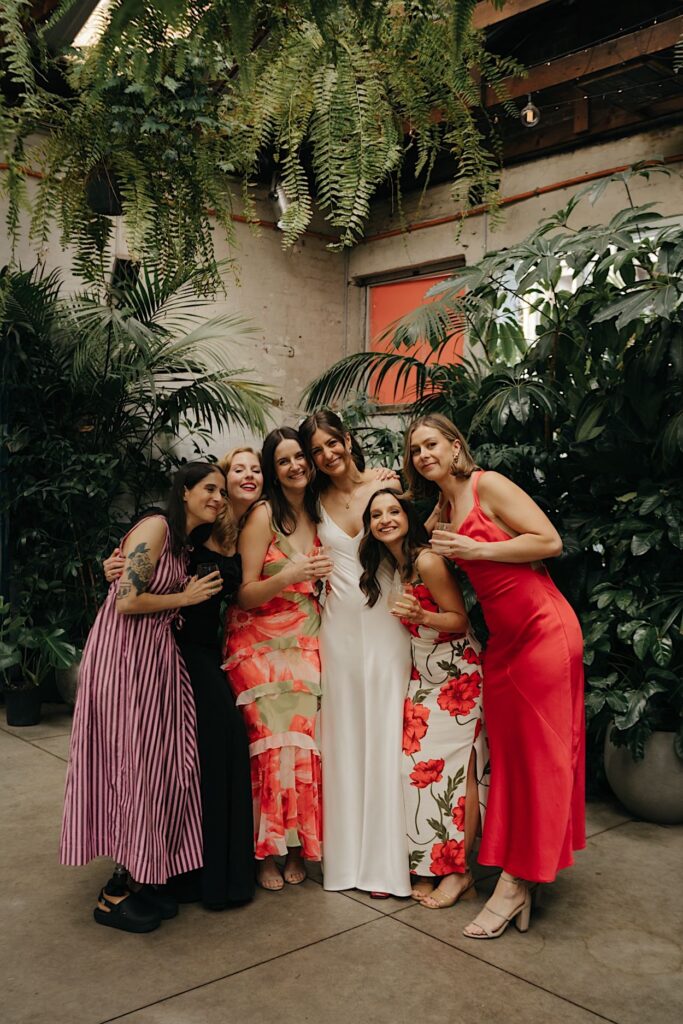 Bridesmaids wearing vibrant red dresses enjoying the wedding reception at Glasshaus Inside in Melbourne.
