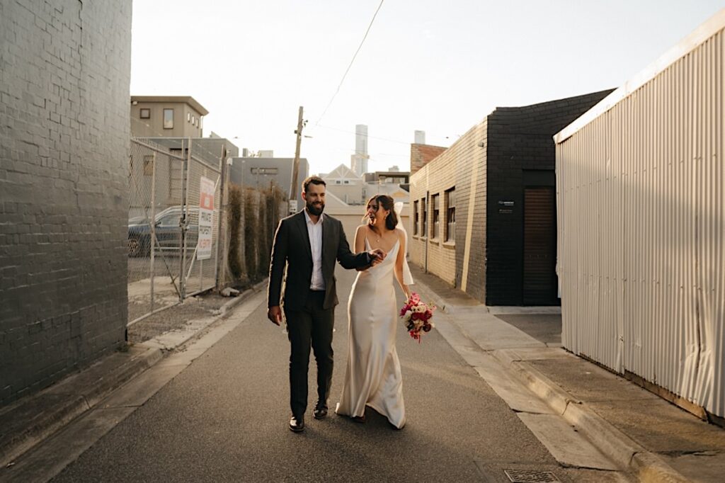 The couple poses for sunset wedding portraits in a nearby laneway during their Glasshaus Inside wedding in Melbourne.