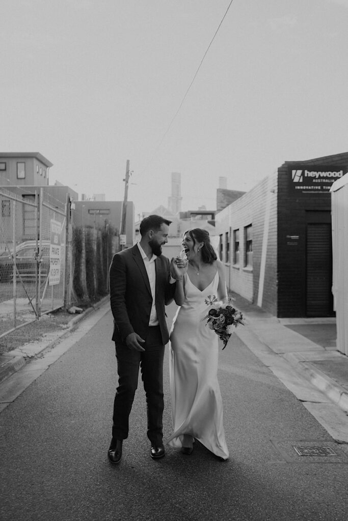 Black-and-white photo of the bride laughing with the groom during sunset wedding portraits at Glasshaus Inside.