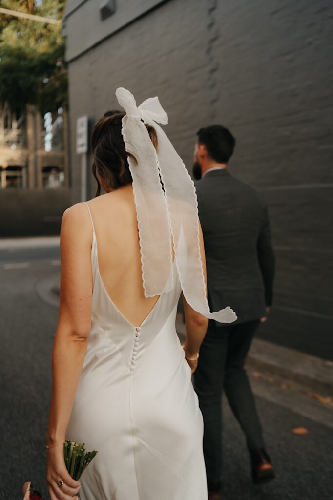 Close-up of the brides’ bow detail on her dress during a Glasshaus Inside wedding.