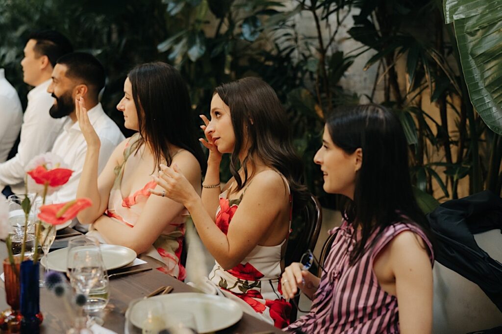 A bridesmaid wiping away tears during a wedding speech at a Glasshaus Inside wedding in Cremorne.