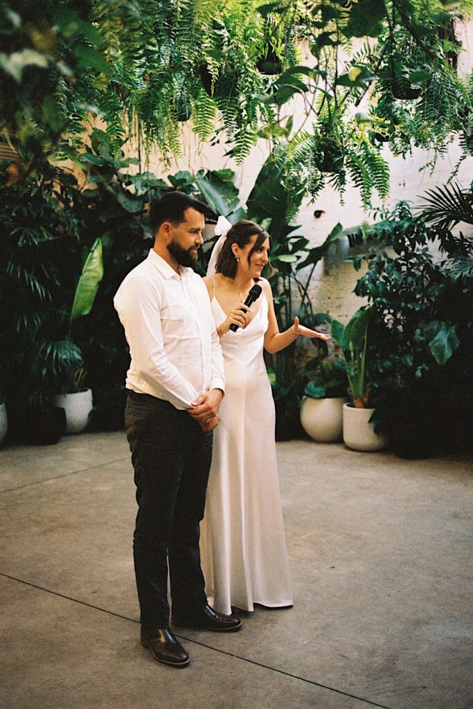 The bride and groom giving a speech during their Glasshaus Inside wedding in Cremorne, captured on 35mm film.