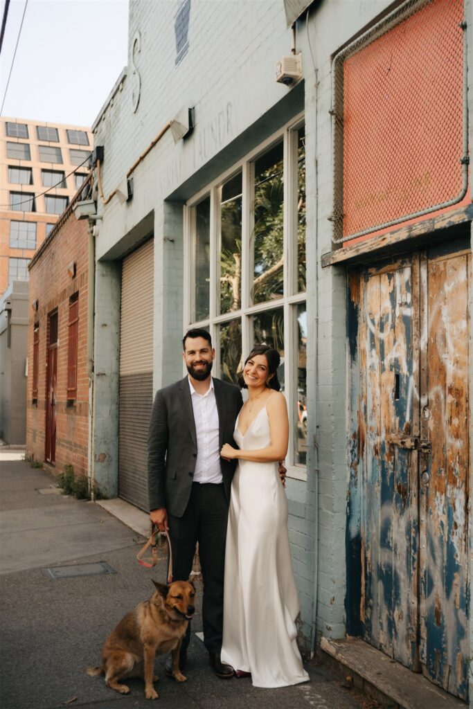 Couple with their dog outside Glasshaus Inside, captured by a Melbourne wedding photographer.
